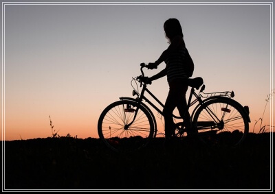 夕方に自転車を乗る女性